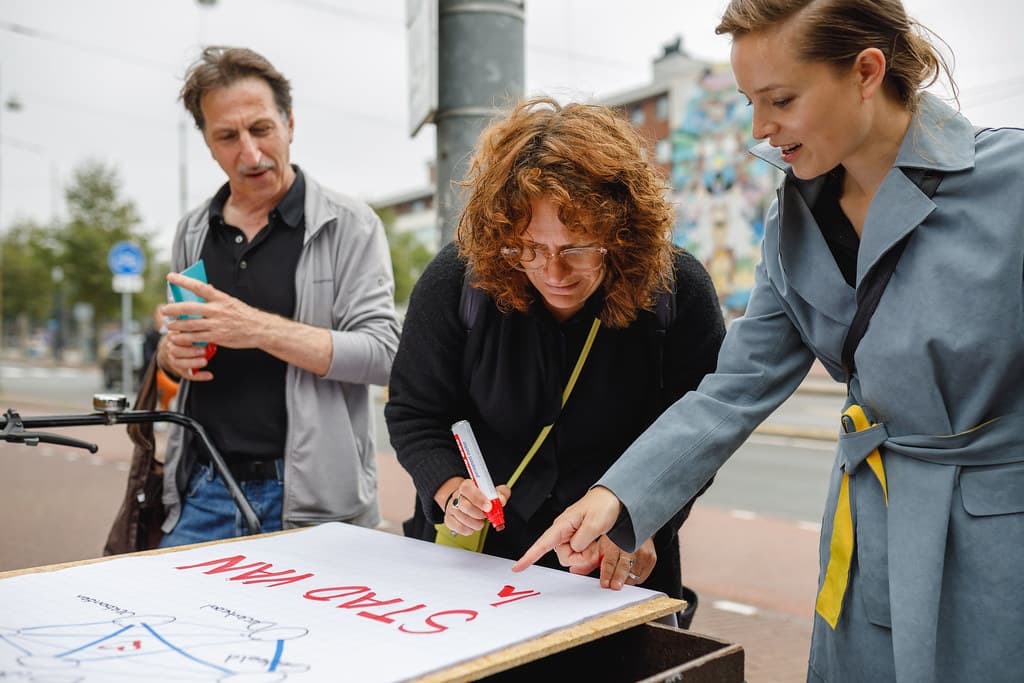 Mensen schrijven samen op een groot vel papier: "stad van..."