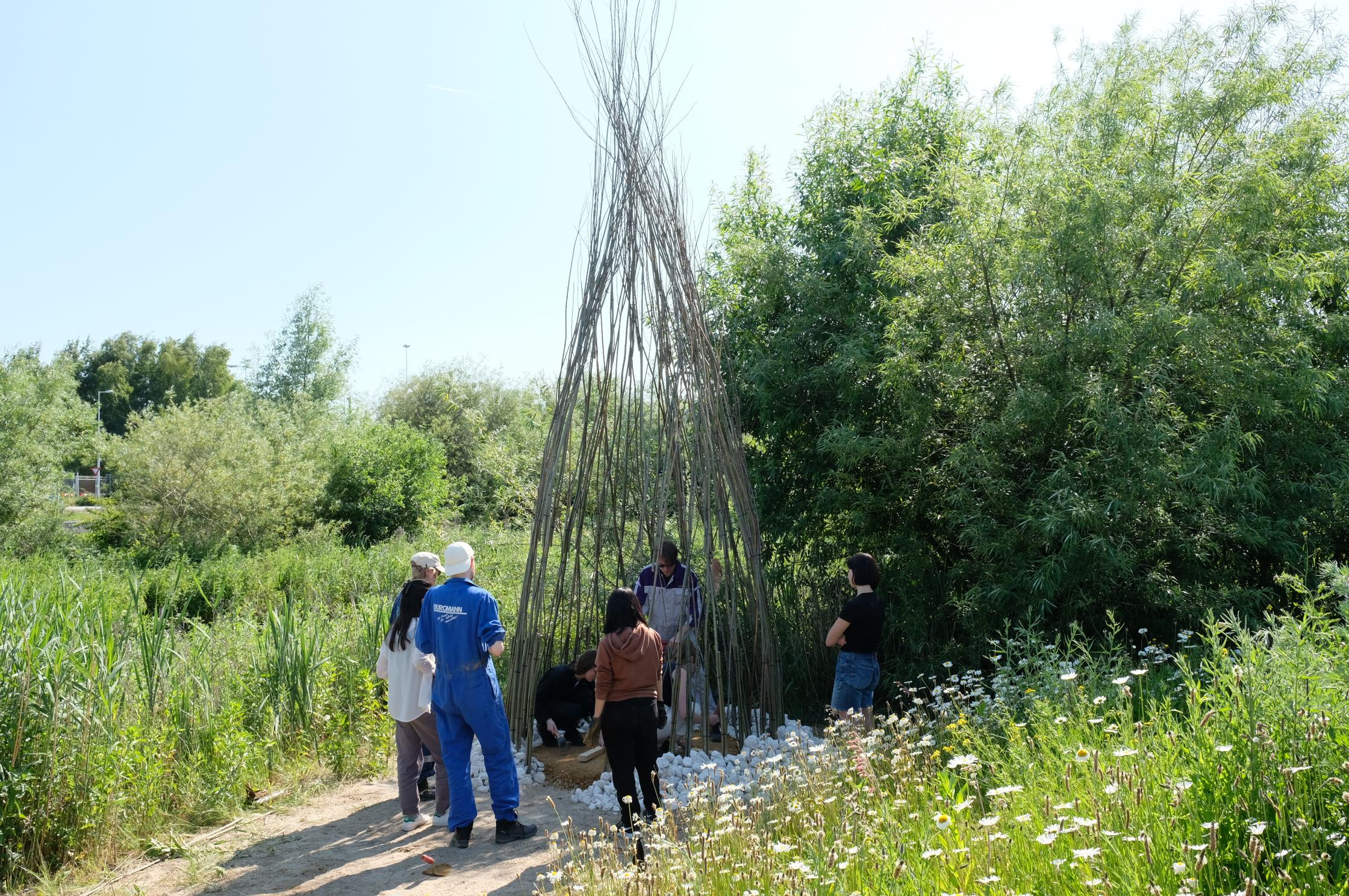 Mensen staan in het groen rondom een interventie in het landschap