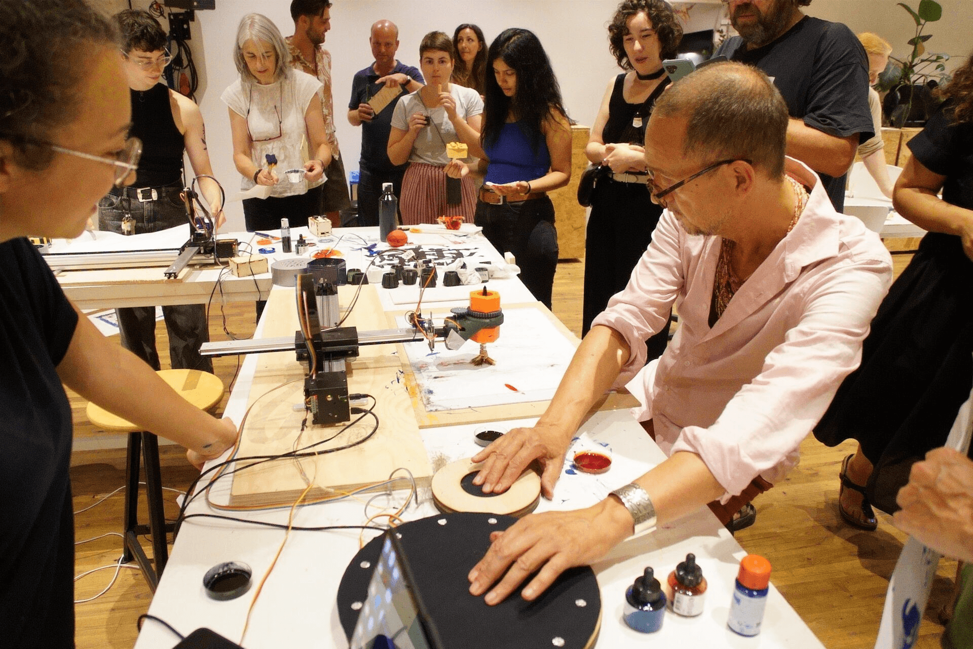 People standing around a table using the HaptiChrome machine at the TextileLab