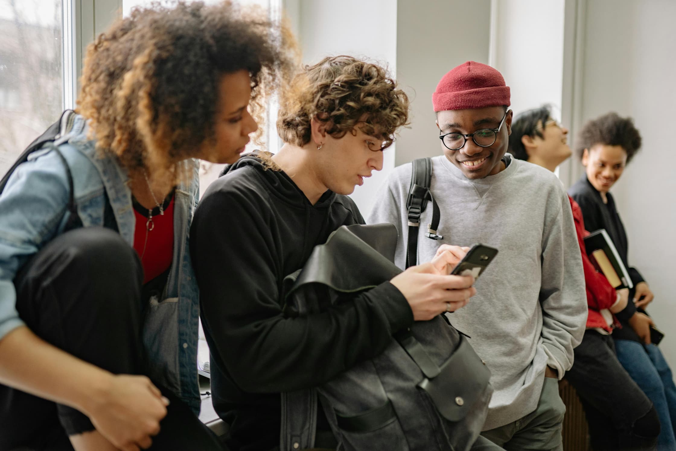 Jongeren kijken samen naar een mobiele telefoon