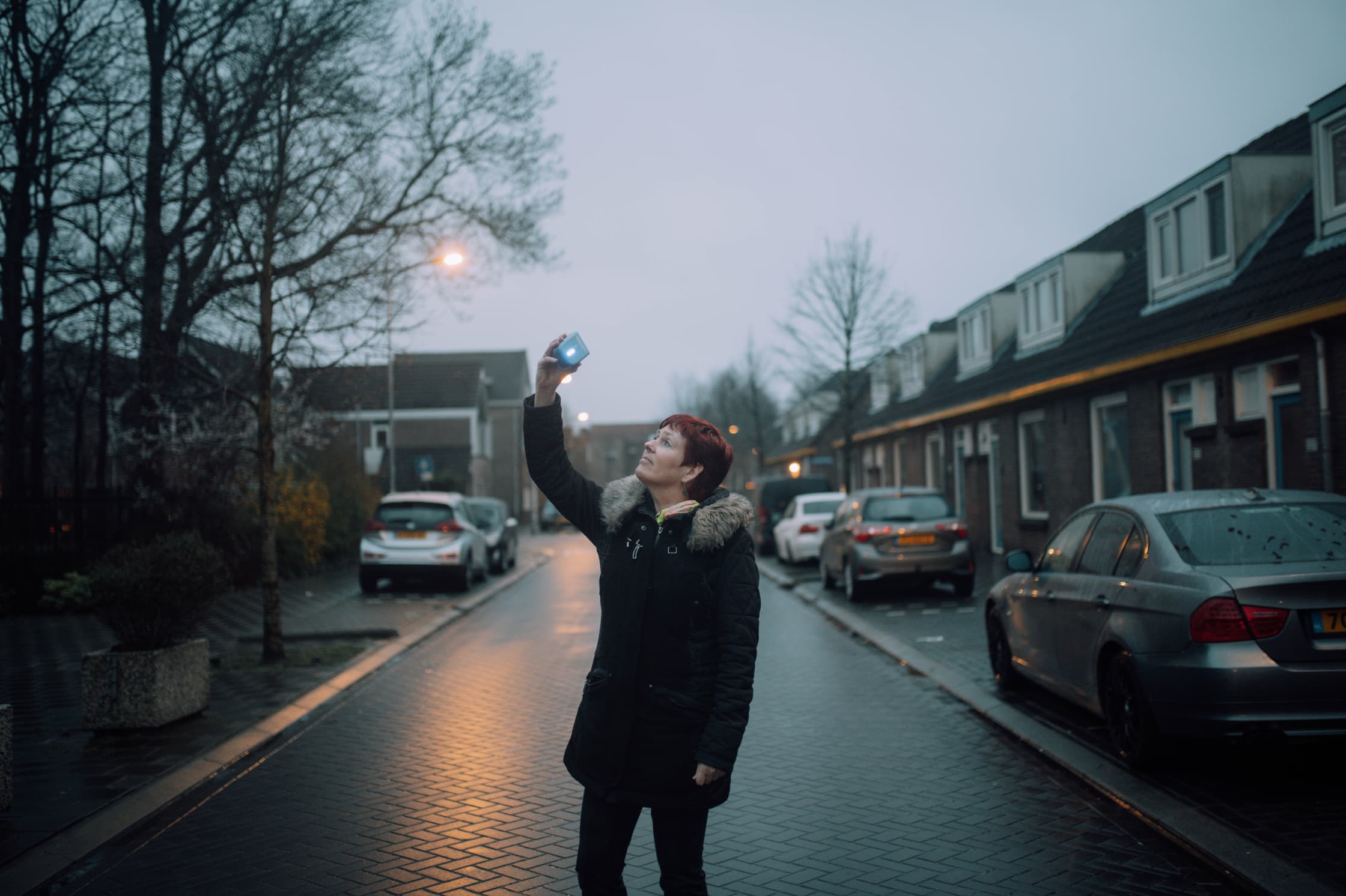 Vrouw meet buiten de lucht met een sensor in haar hand