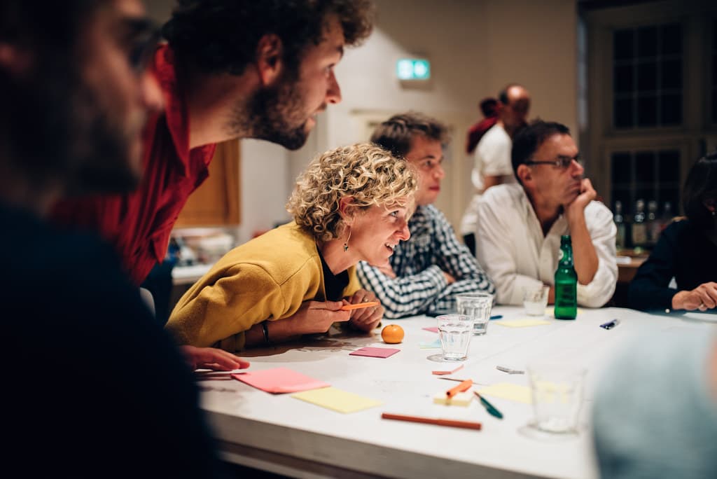 Mensen zitten aan een workshop tafel samen