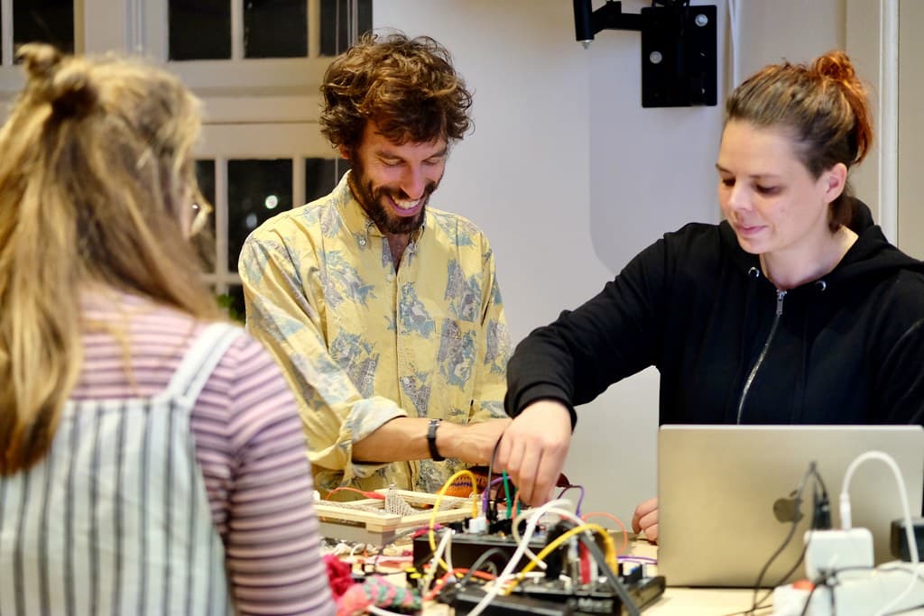 Mensen tijdens Waag Open workshop over textiel handwerken met machines