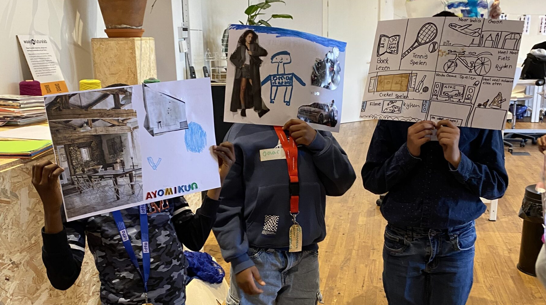 Children holding up their designs for a costume