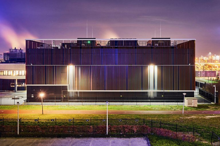 A huge black data center with a pruple sky in the background