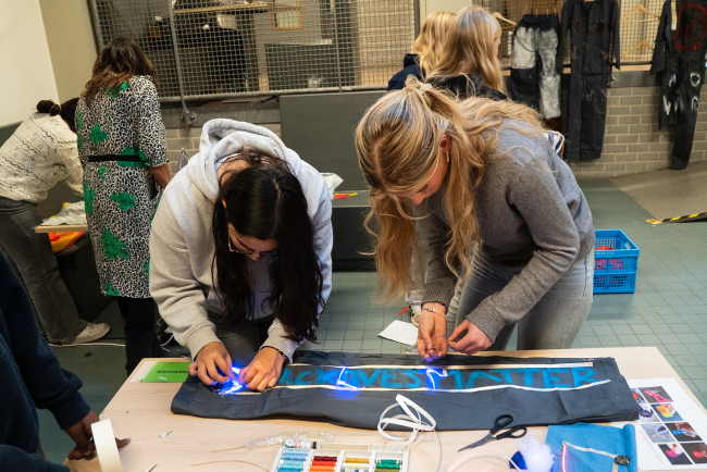 Twee leerlingen werken samen aan een statement op het uniform